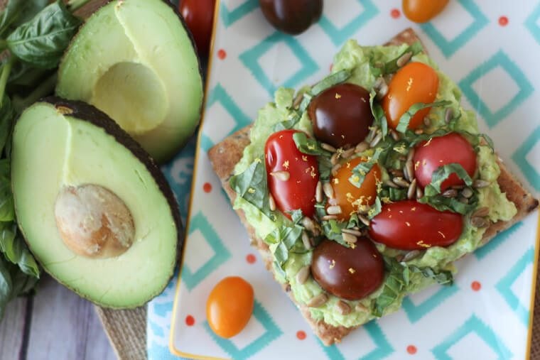 An avocado toast with tomatoes on top.