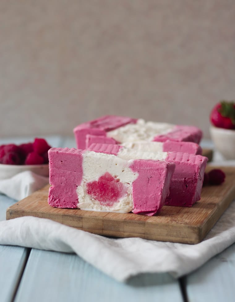 Sliced ice cream cake that looks like a Canadian flag on a serving board.