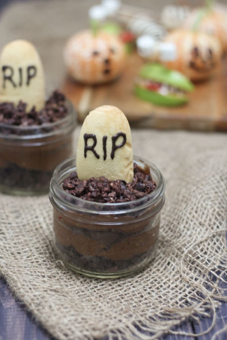 A close up of a Halloween graveyard mousse with an edible gravestone saying RIP in chocolate.