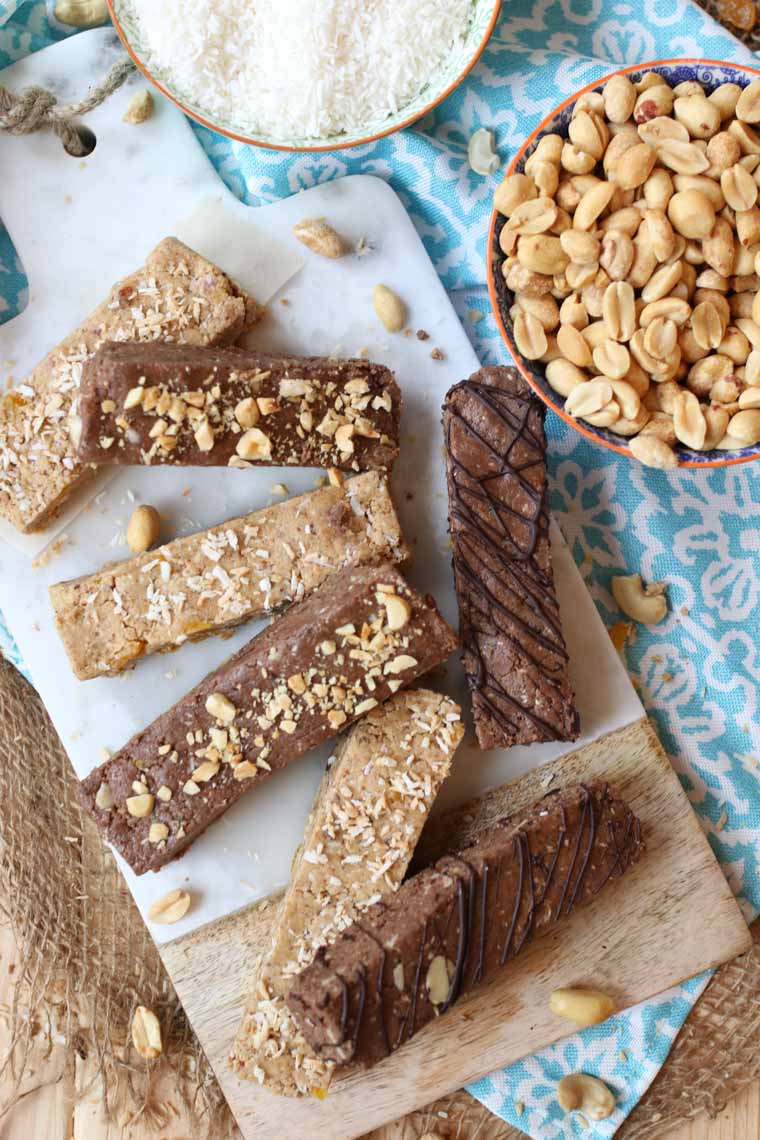 birds eye view of vegan and gluten free protein bars on a wooden surface next to a bowl of peanuts