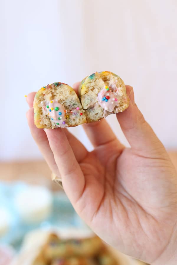 hand holding two rainbow twinkies filled with strawberry protein cream