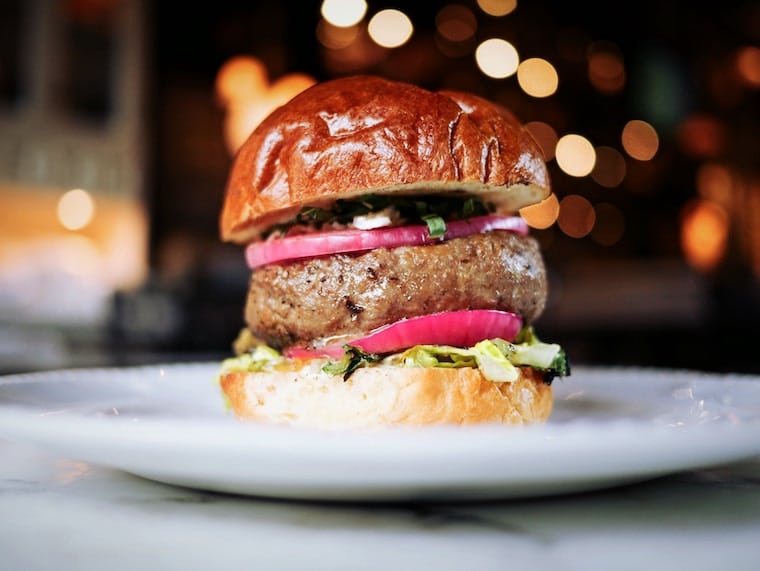 A juicy burger on a plate.