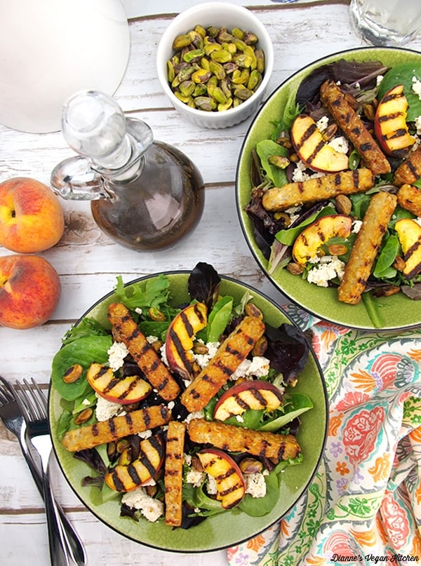 Grilled tempeh salad with peaches in a green bowl. 
