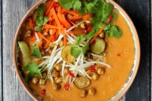 Close up image of vegan curry soup with crispy chickpeas garnished with lime and cilantro.