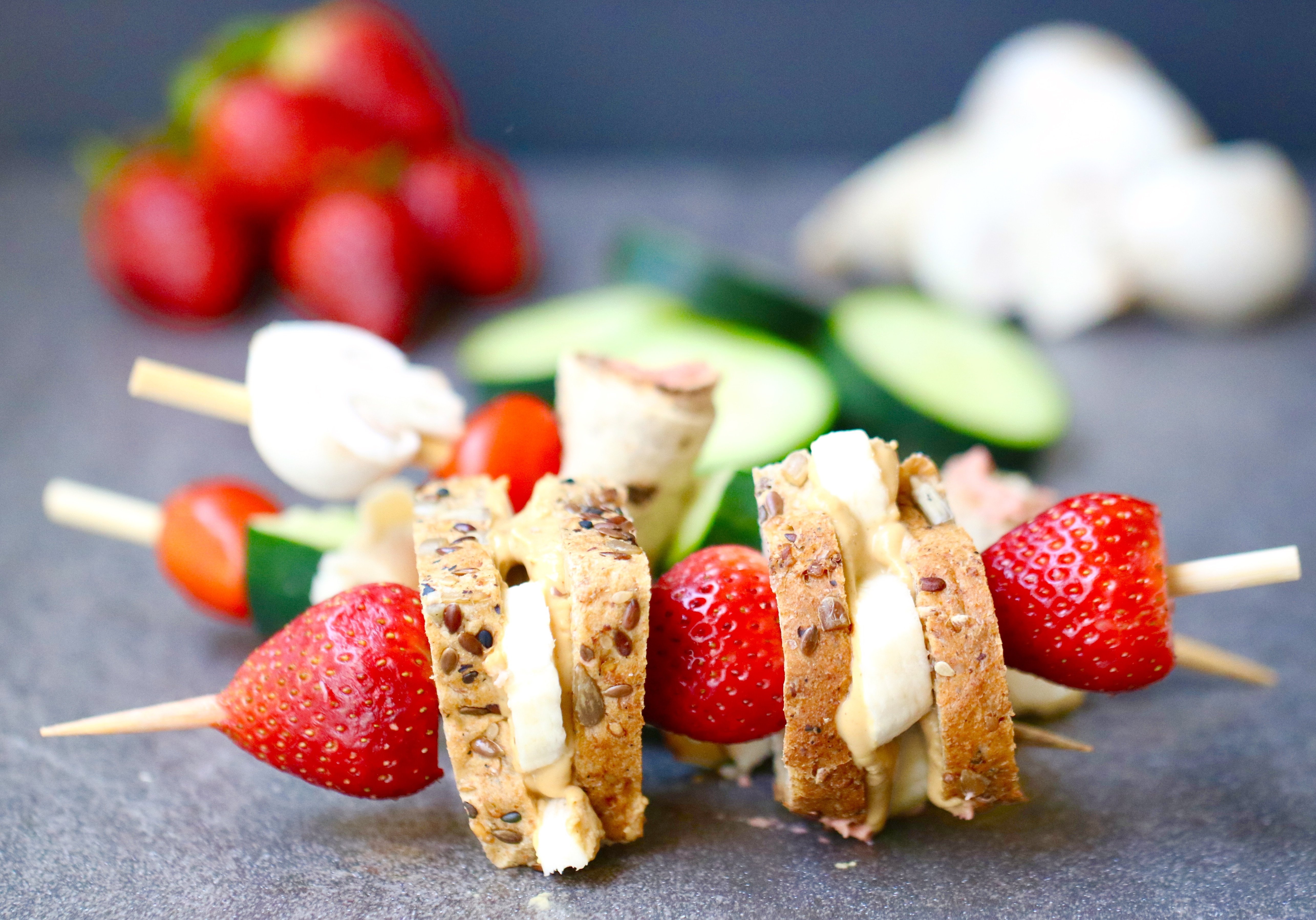 Mini sandwiches on a skewer with strawberries.