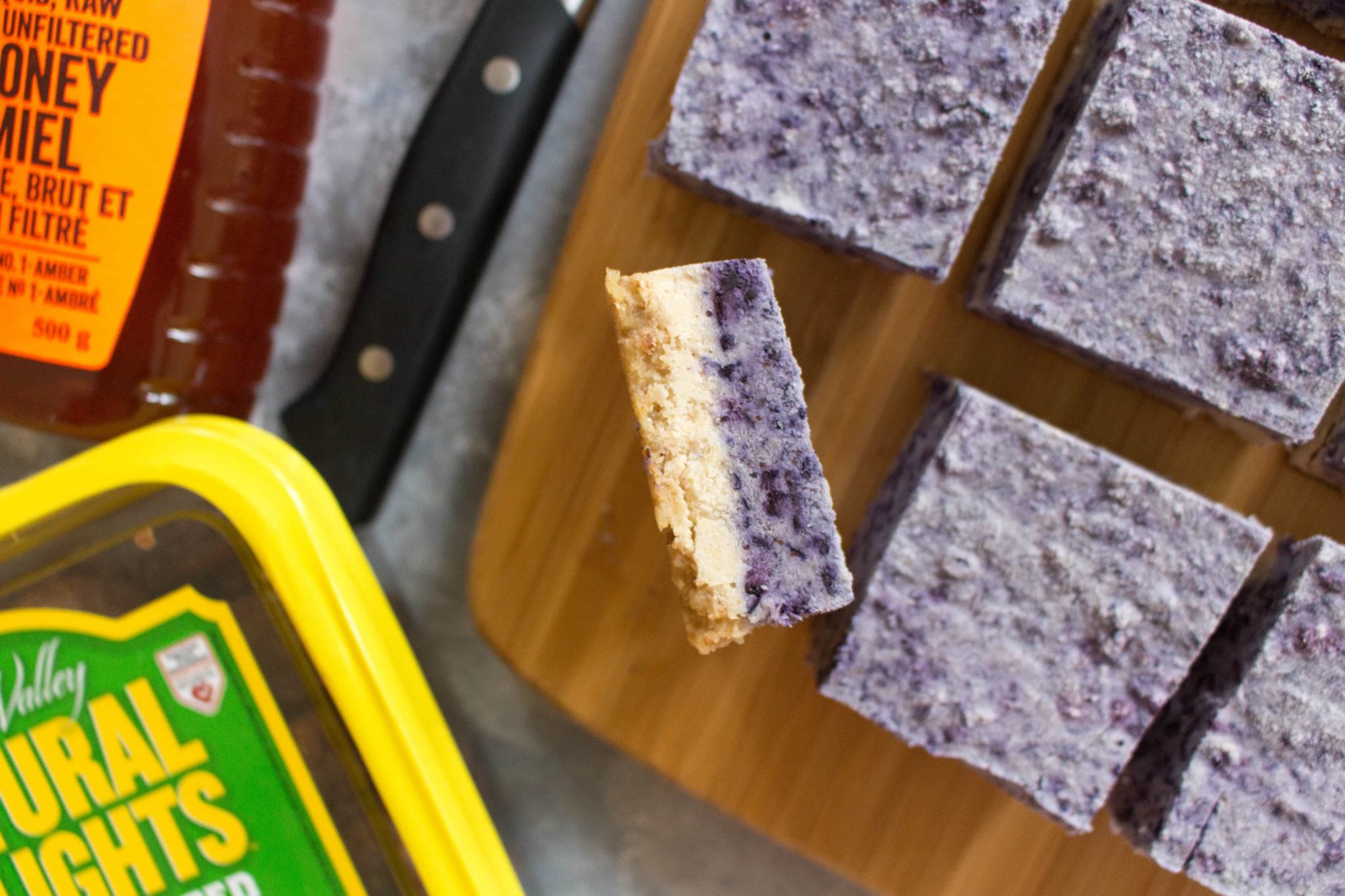 birds eye view image of no bake gluten free vanilla blueberry cashew bars on a wooden surface