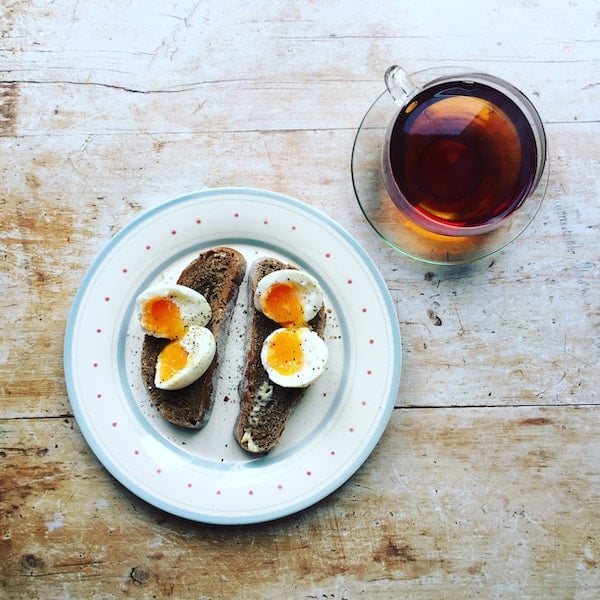 Birds eye view of eggs and toast on a white plate as a postpartum hair loss help.
