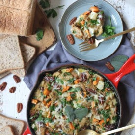 Vegetable strata served in skillet next to a serving plate.