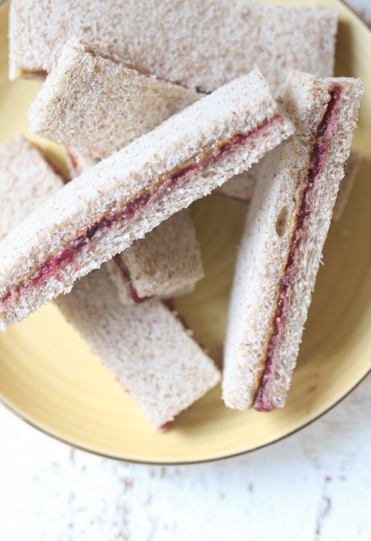 Peanut butter and jelly finger sandwiche on a yellow plate.