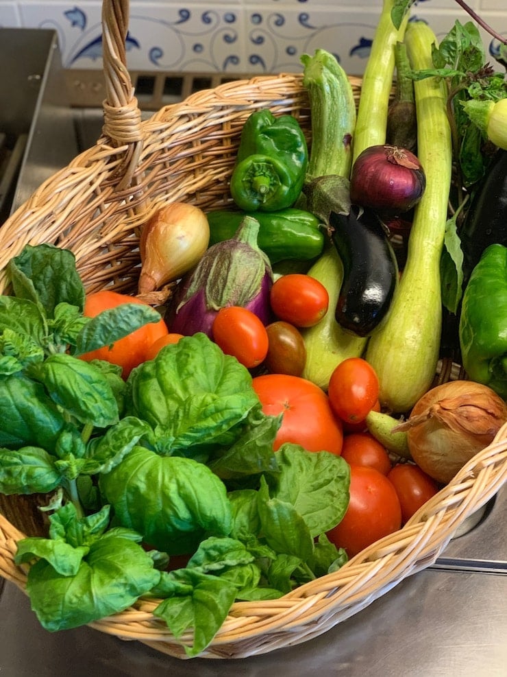 Basket full of vegetables and herbs.