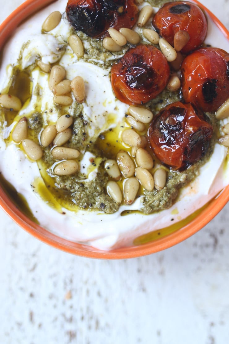 greek Yogurt bowl topped with pesto and tomatoes.