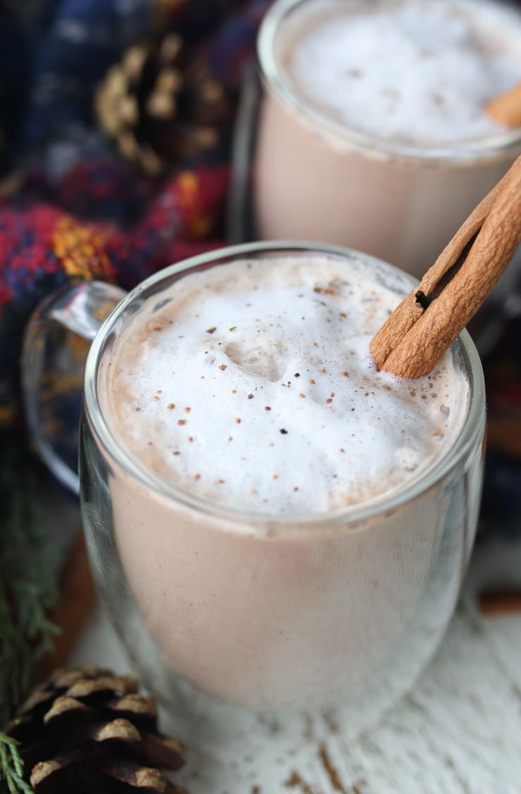 Chocolate Egg nog drink in a clear mug garnished with a cinnamon stick