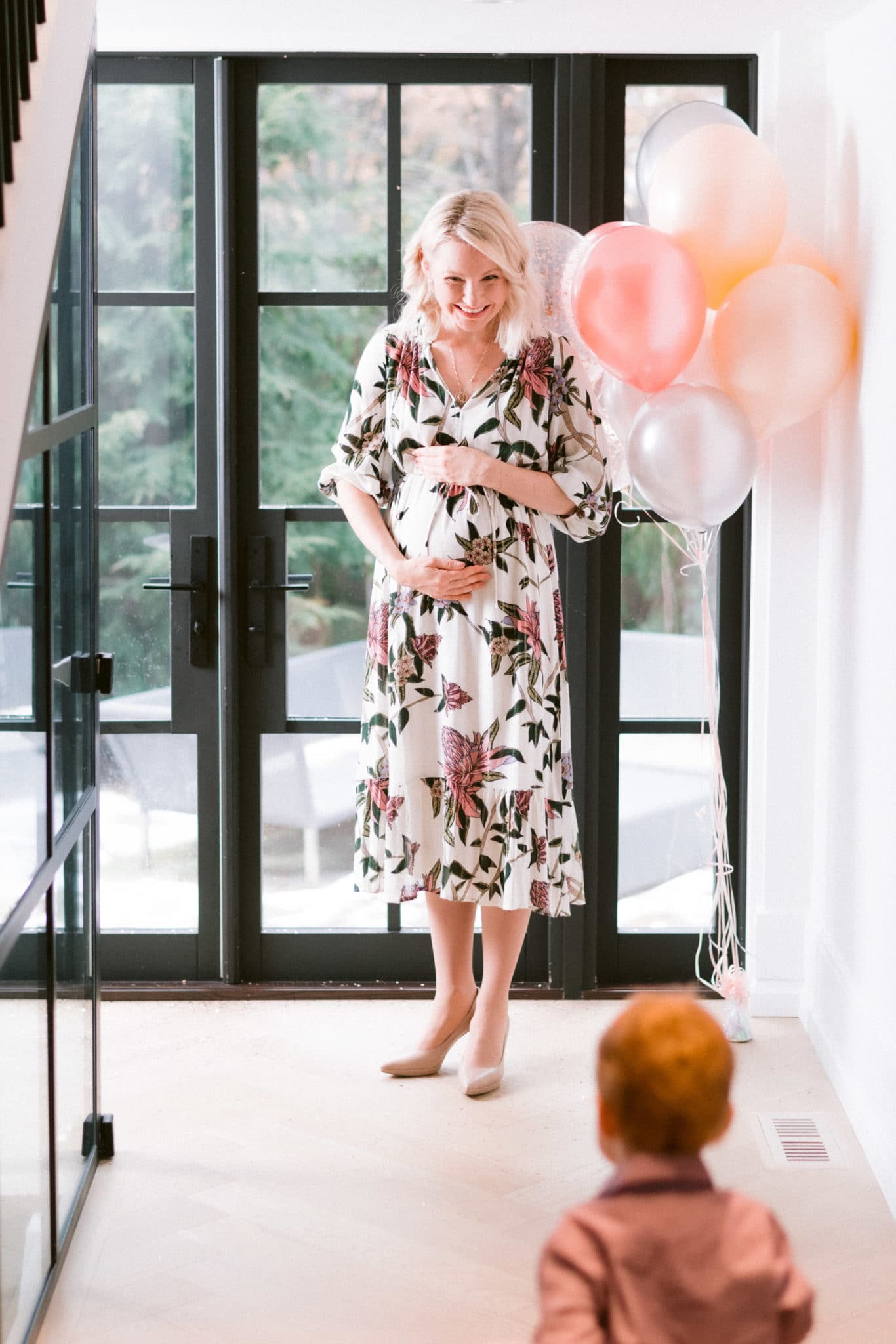 abbey in floral dress with baby E running towards her