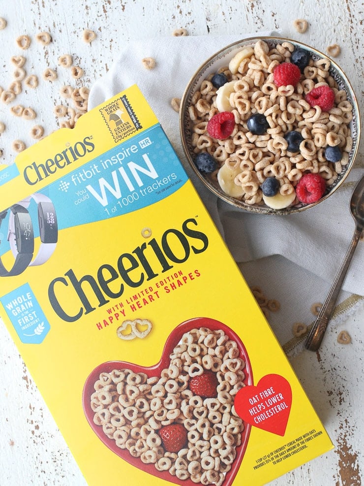Birds eye view of cheerios box and bowl of cheerios with berries for a heart healthy diet.