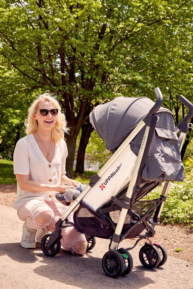 Abbey outside in a white blouse with her baby in a stroller as a fun outdoor activity.