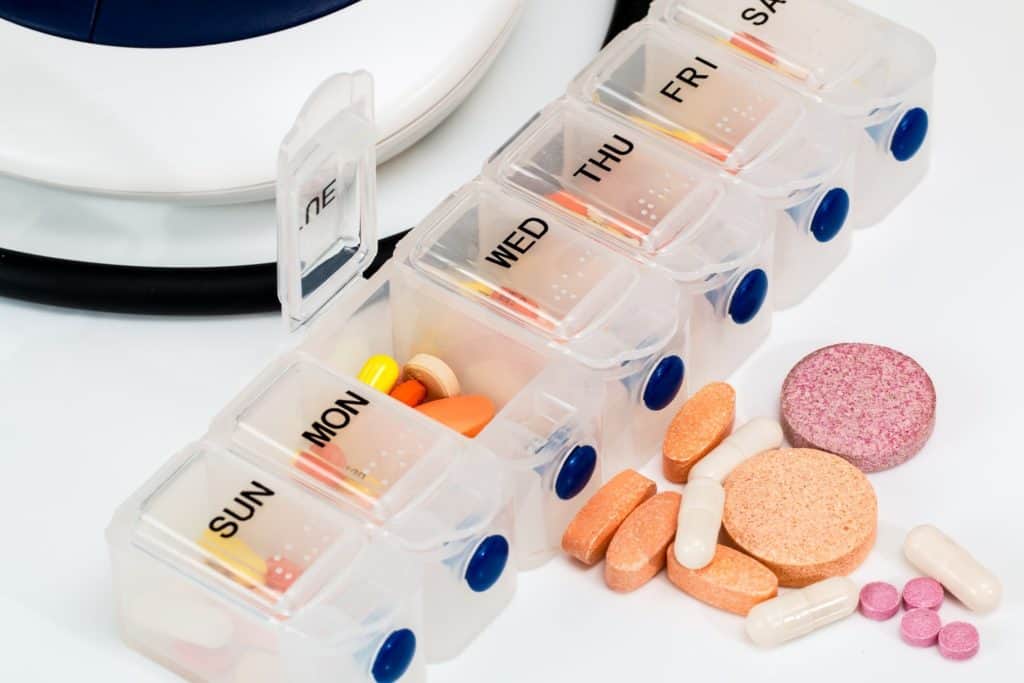 Several vitamins and probiotics in a vitamin dispenser.