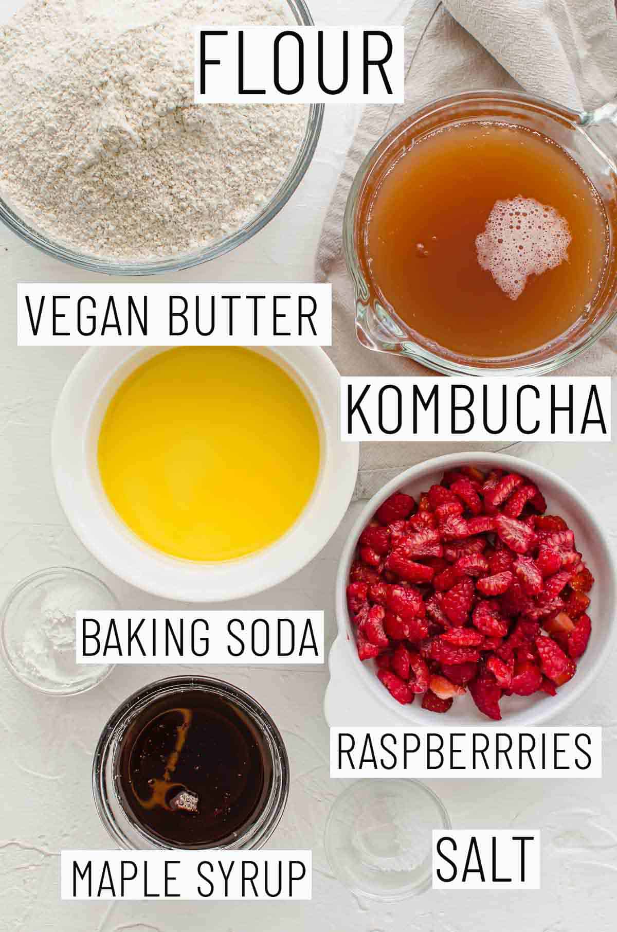 Flat lay images showing portioned recipe ingredients including kombucha, vegan butter, flour, raspberries, maple syrup, baking soda, and salt]. 