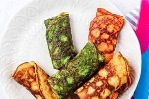 Pinterest graphic of a plate of colourful rolls of egg with the text overlay "cheese omelette with veggies."