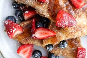 Overhead view of a plate of low carb french toast with powdered sugar and berries.