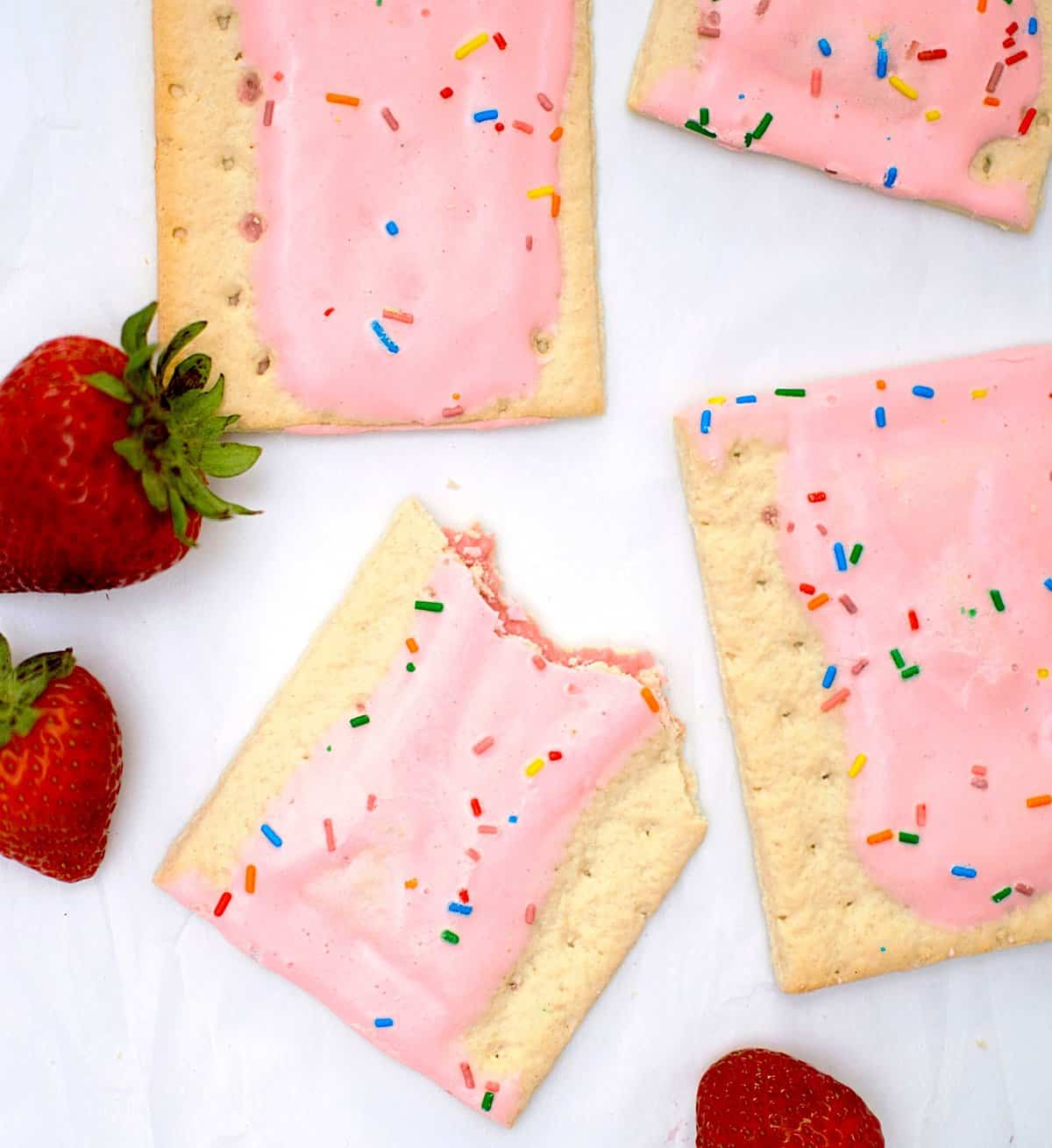 Flatlay of pink pop tarts and strawberries.