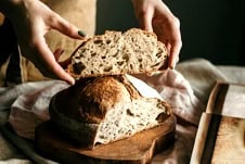Trad wife influencer holding sourdough bread.