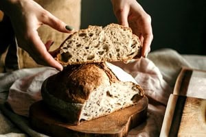 Trad wife influencer holding sourdough bread.