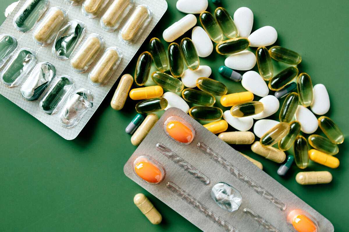 Various dietary supplements scattered against a green background.
