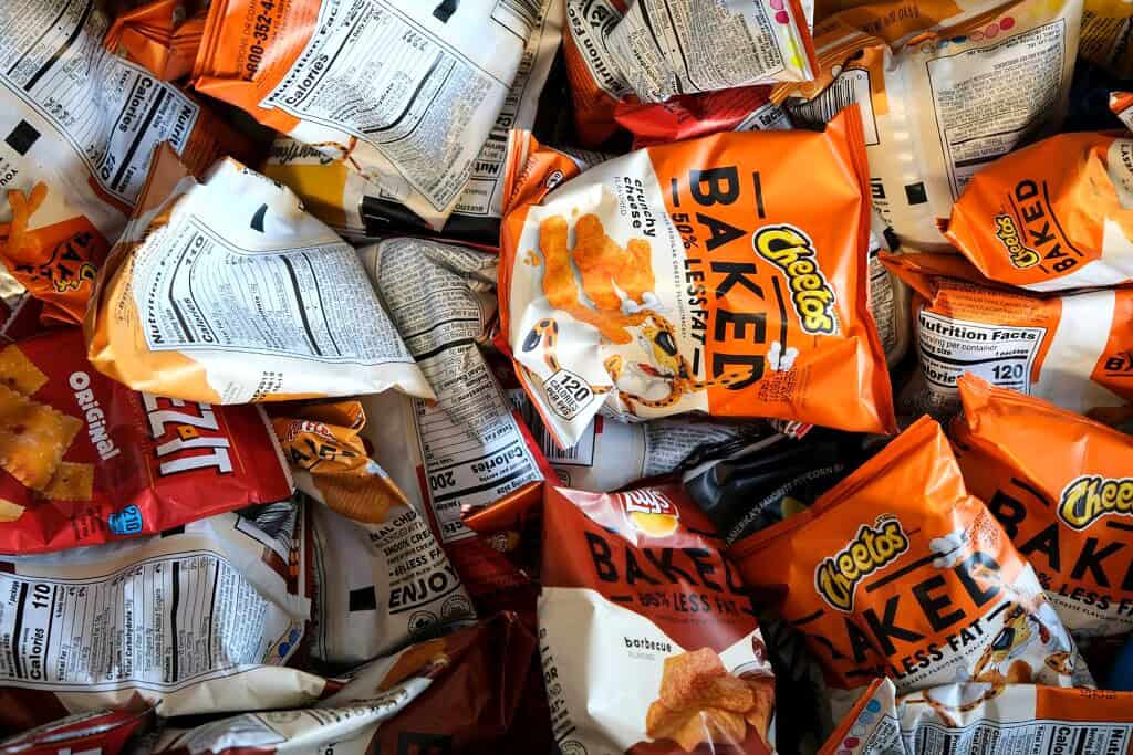 birds eye view of a bunch of bags of chips including cheez its and baked cheetos.