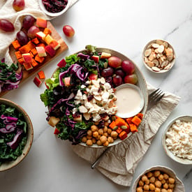 Bowl of tahini crunch salad with grapes, feta, chickpeas, sweet potato and tahini greek yogurt dressing.
