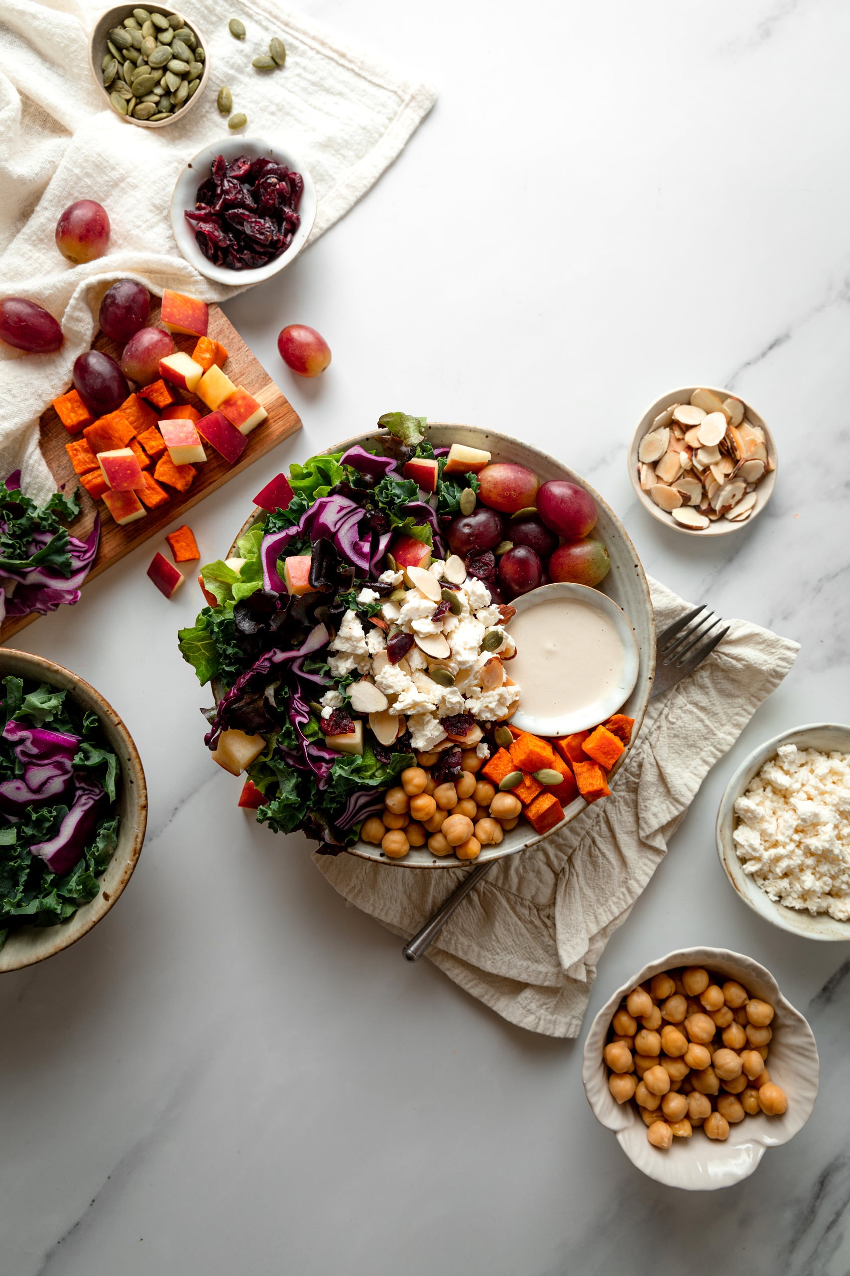 Bowl of tahini crunch salad with grapes, feta, chickpeas, sweet potato and tahini greek yogurt dressing.